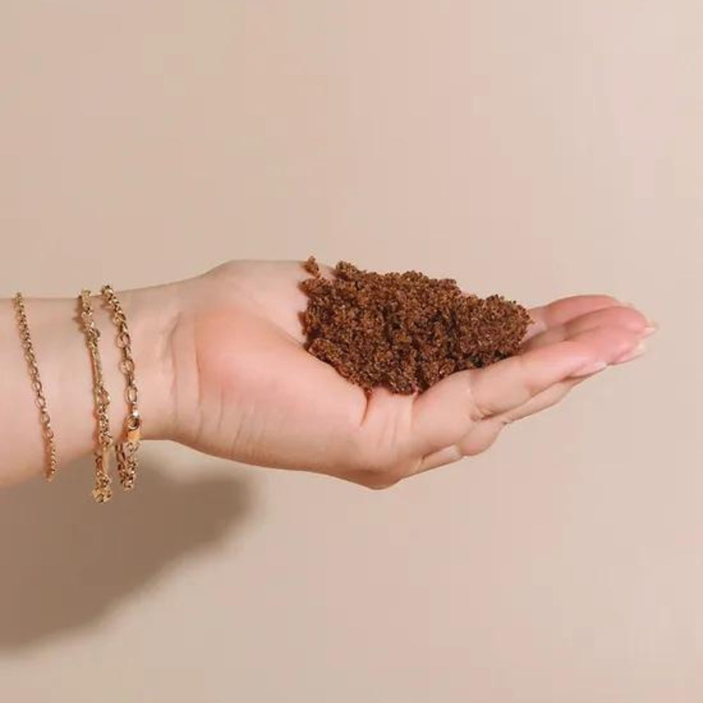 A hand holding body scrub, the product is a gentle body scrub, this product help with bumpy, rough, and dry skin. 