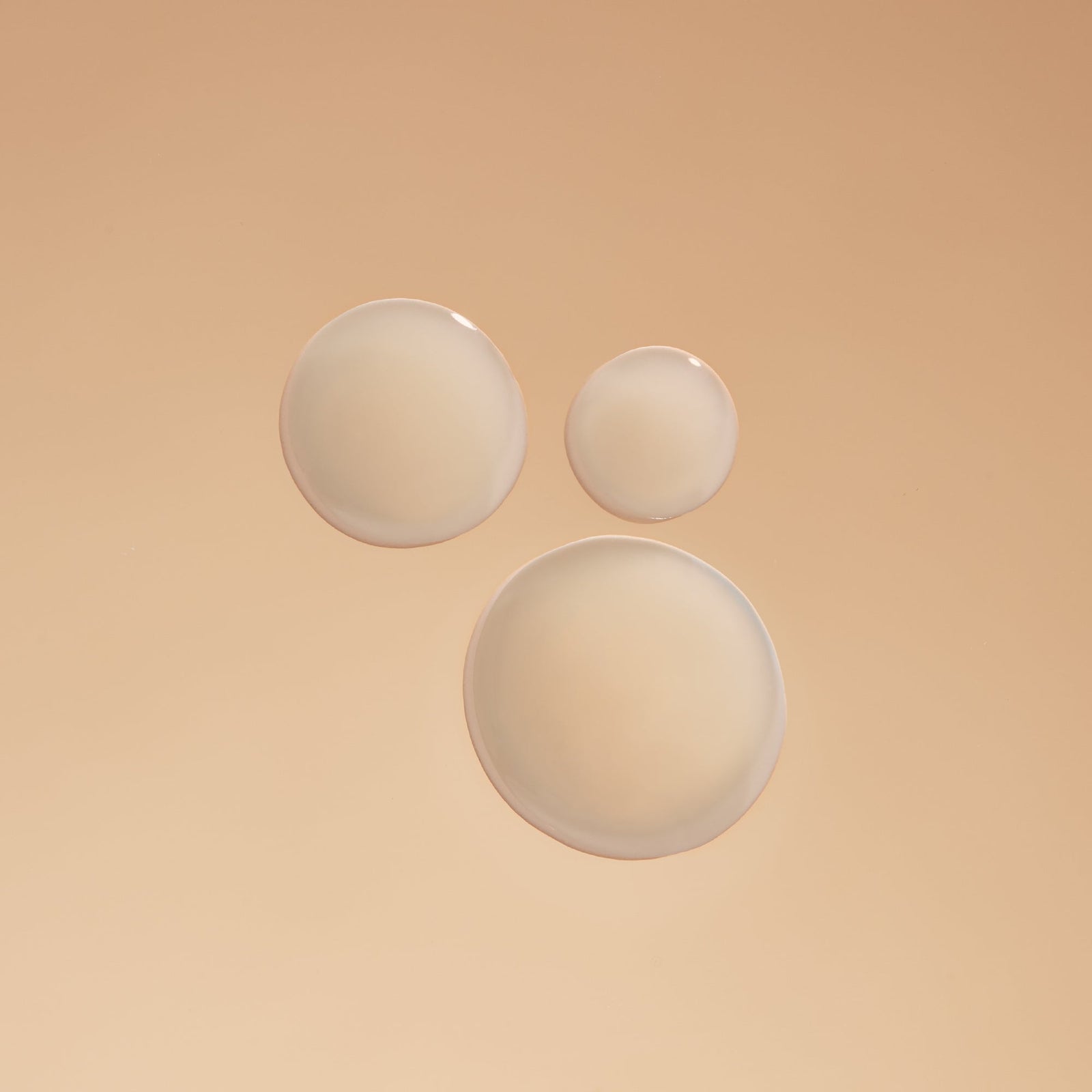 Close-up of Indira Organics Acne Serum texture with smooth droplets on a neutral background, showcasing natural skincare product for acne treatment