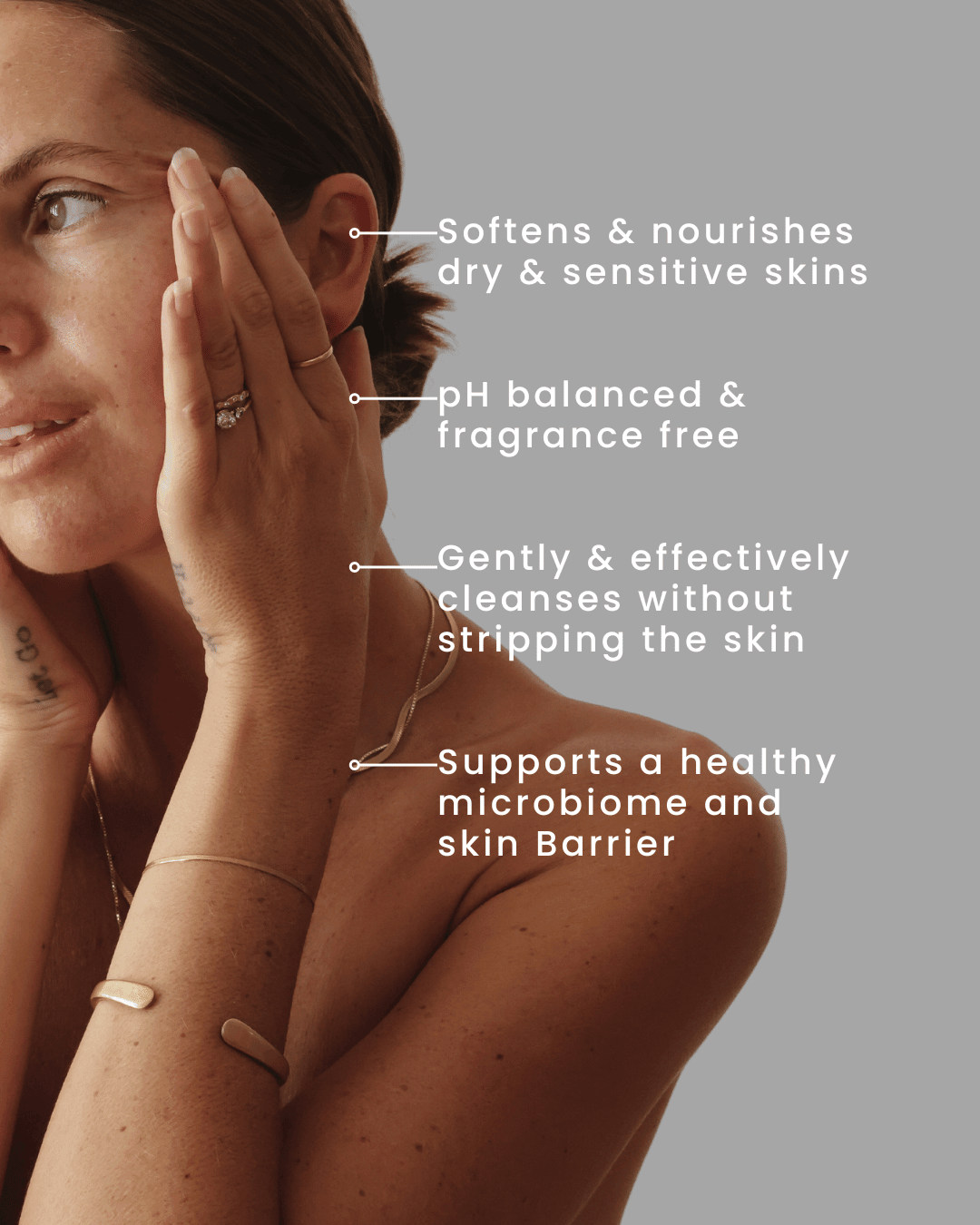 Woman touching her face with text highlighting skincare benefits on a gray background, face wash for sensitive combination skin