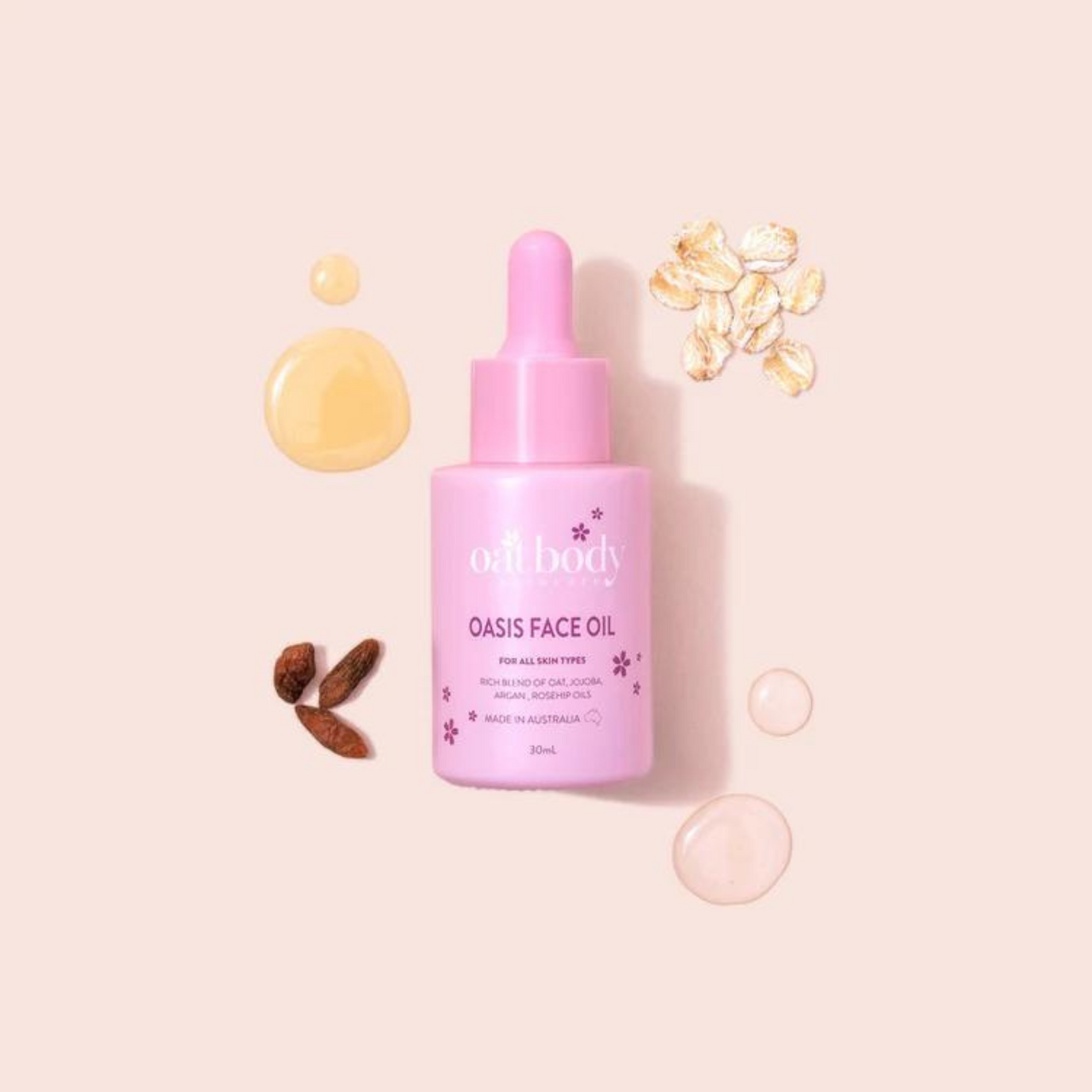 Oatbody Oasis facial oil in a pink bottle with dropper, accompanied by drops of yellow oil, oat flakes, and almond pieces on a soft pink background, this is an Australian made skincare product.