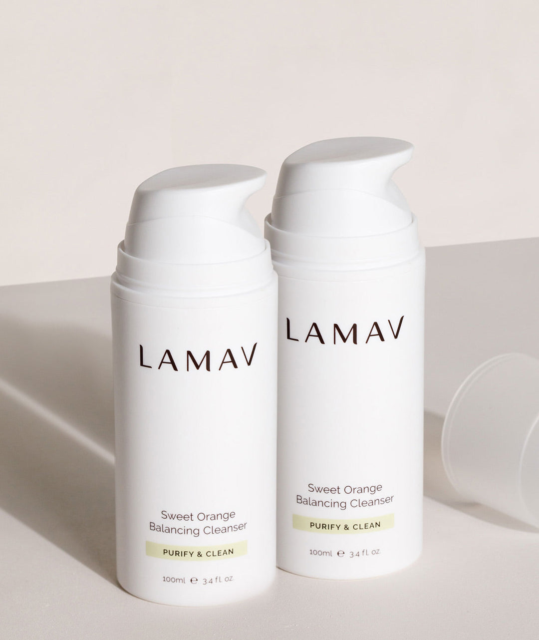 Two white bottles of LAMAV Sweet Orange Balancing Cleanser on a light background
