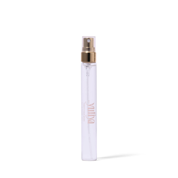 Clear spray bottle with gold cap on a white background