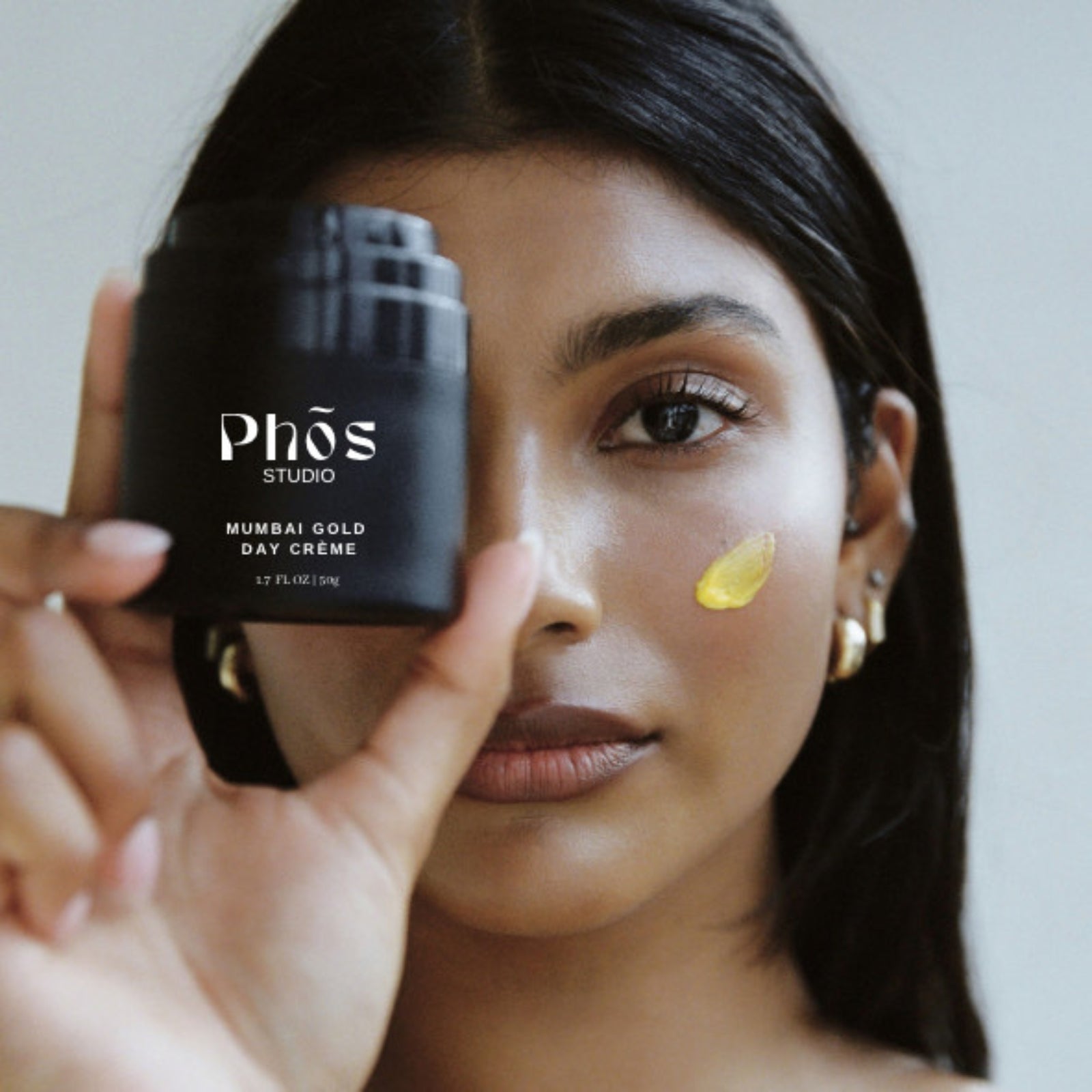 Model applying Phos Studio Mumbai Gold Day Crème, face moisturiser, a nourishing Ayurvedic skincare product for dry skin, available at VAMS Beauty, an online beauty and skincare shop offering premium natural beauty products made in Australia.