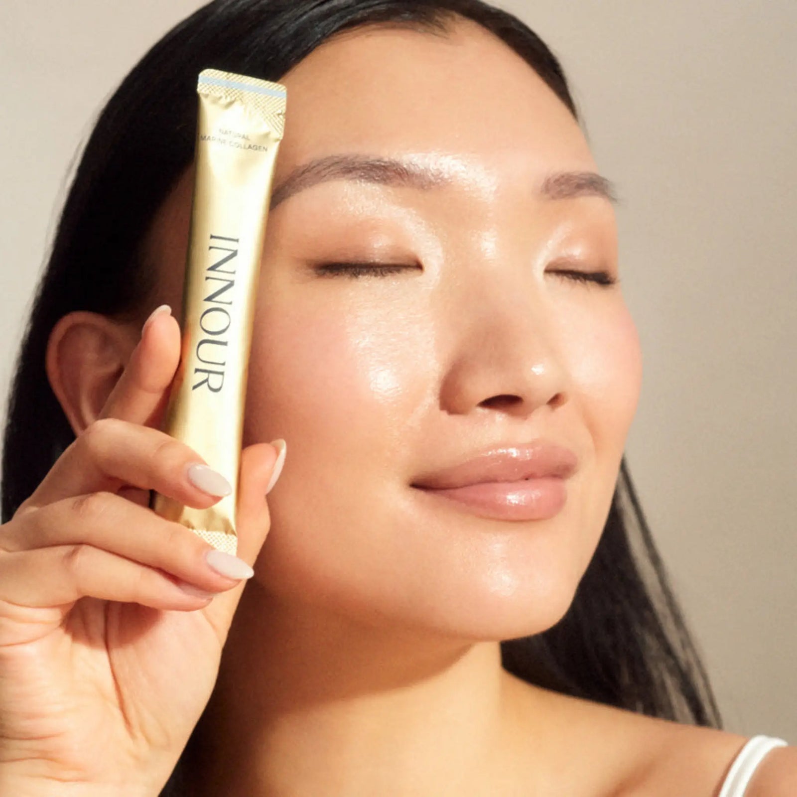 Radiant model holding an Innour natural collagen powder sachet, showcasing the glow-boosting benefits of premium marine collagen australia.