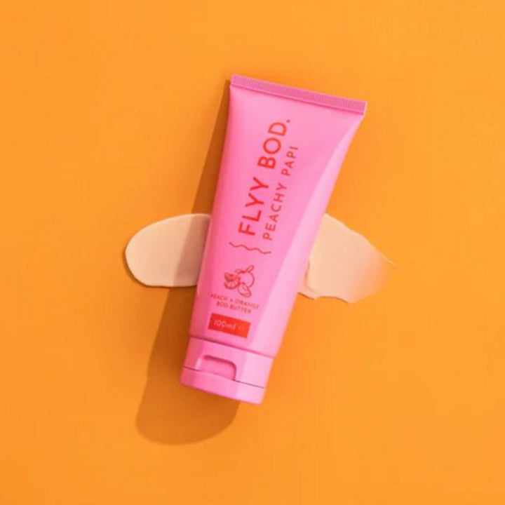 Vibrant pink tube of Body Butter, infused with peach and orange, 100ml size. The bold and colorful packaging is beautiful. Made in Australia, Aboriginal Owned body care range, a nourishing and fragrant skincare product that hydrates and moisturises dry skin. 
