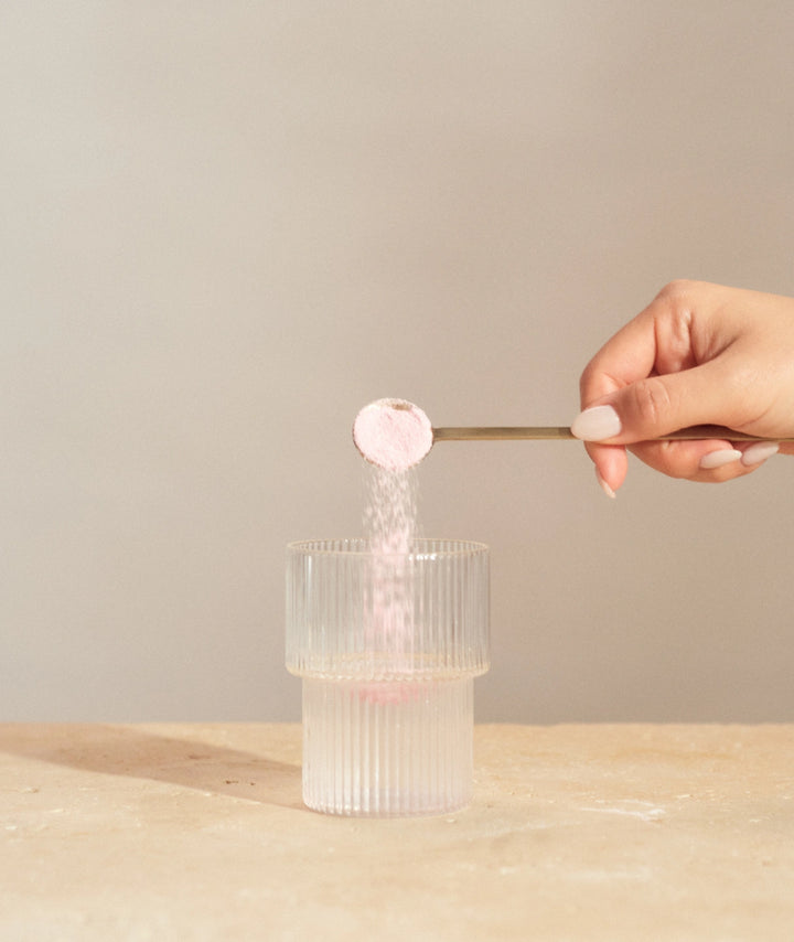 Innour Natural Marine Collagen Berry 348g powder being added to a glass, showcasing dissolvable marine collagen supplement for skin hydration, hair and nail support in Australia.