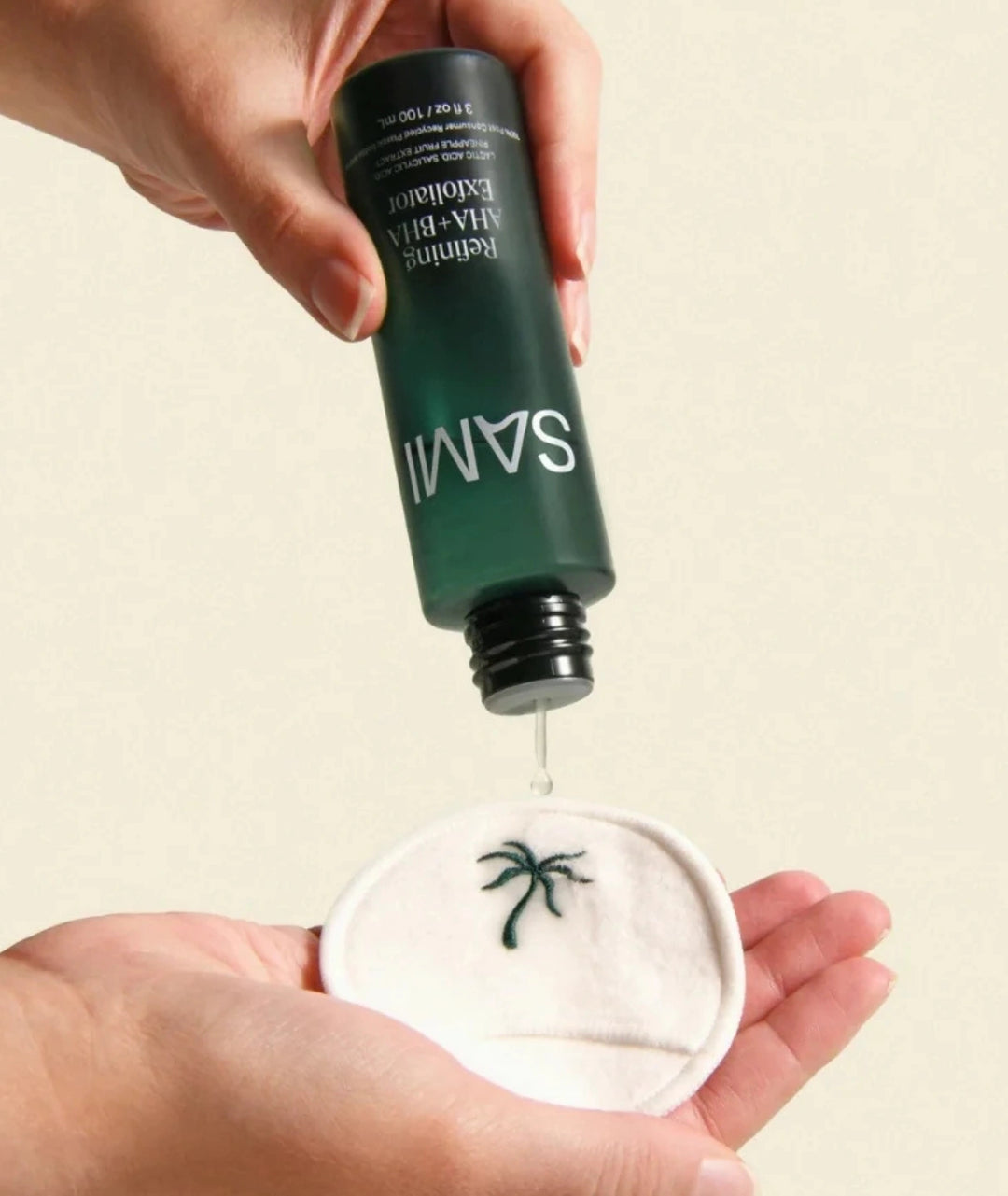 Refining AHA + BHA Exfoliator by SAMI — liquid formula pouring onto a reusable cotton pad