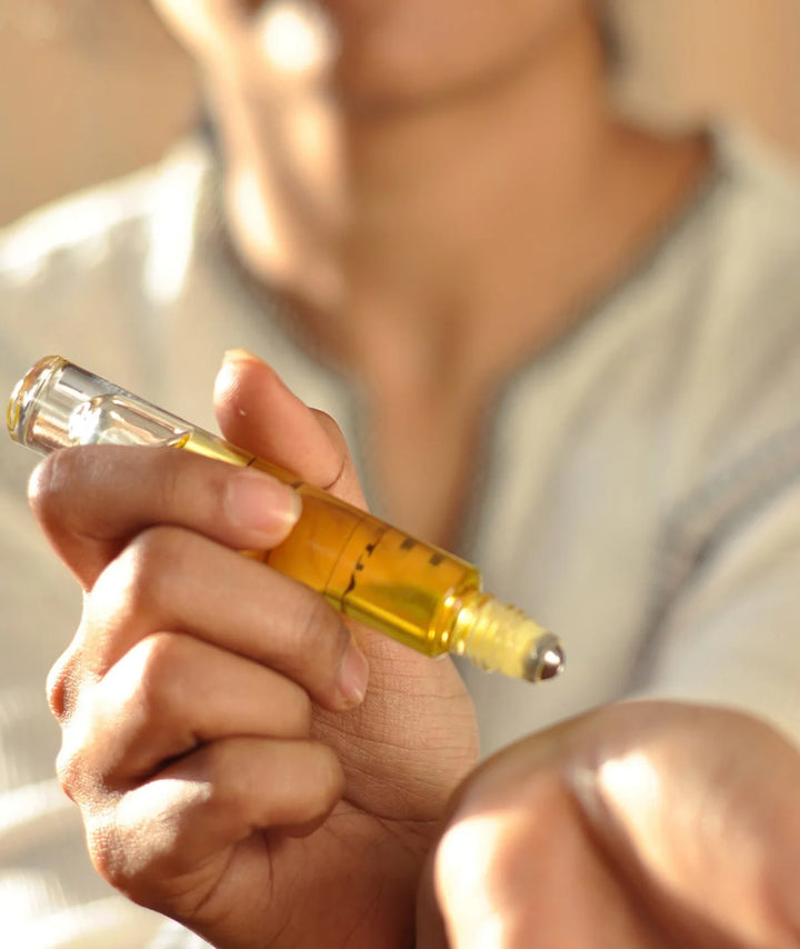 Applying Serene Bodyhealth Amplify essential oil perfume rollerball to skin.