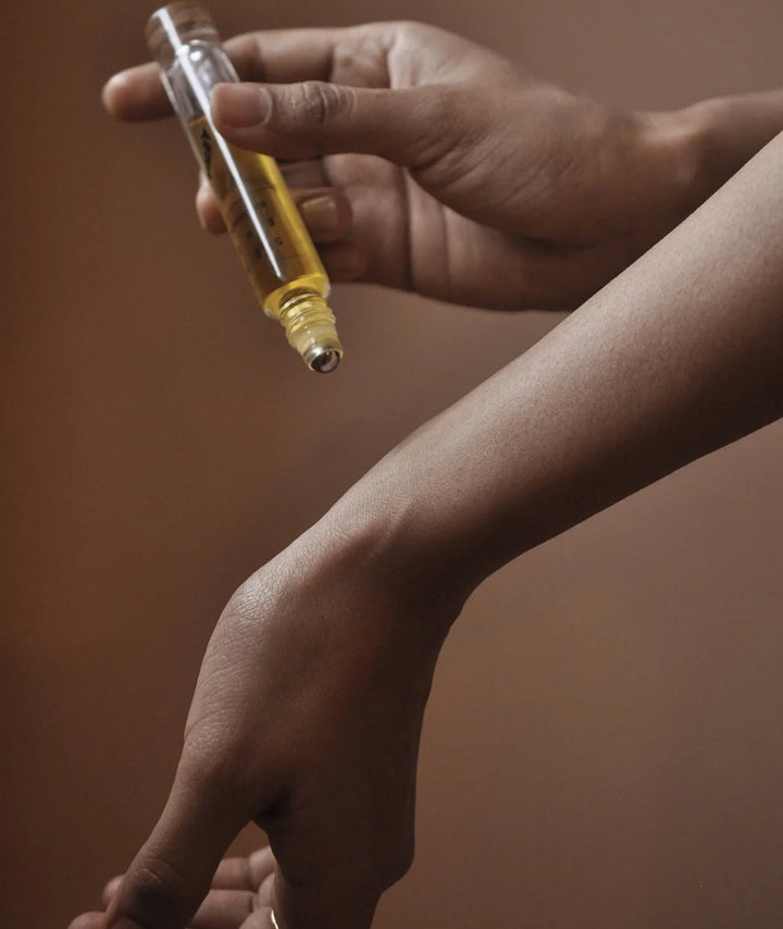Applying Serene Bodyhealth Rest essential oil perfume rollerball directly onto wrist pulse point.