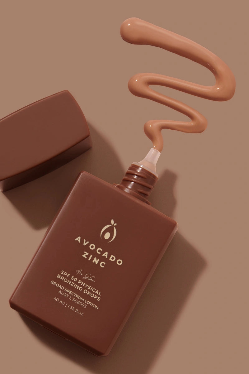 Avocado Zinc bronzing drops for face product with a droplet of lotion on a brown background