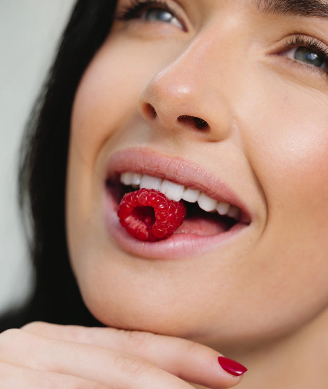 Woman holding a raspberry, Innour berry marine collagen