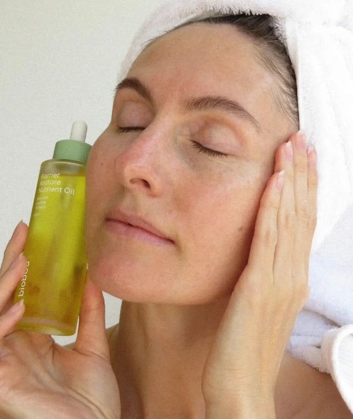Woman applying Biobod Barrier Restore facial oil to nourish dry skin