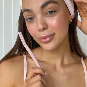 Close-up of a young woman using a pink BondiBlades dermaplaning razor for facial exfoliation, available at VAMS Beauty, an Australian online beauty shop known for premium skincare tools and products.