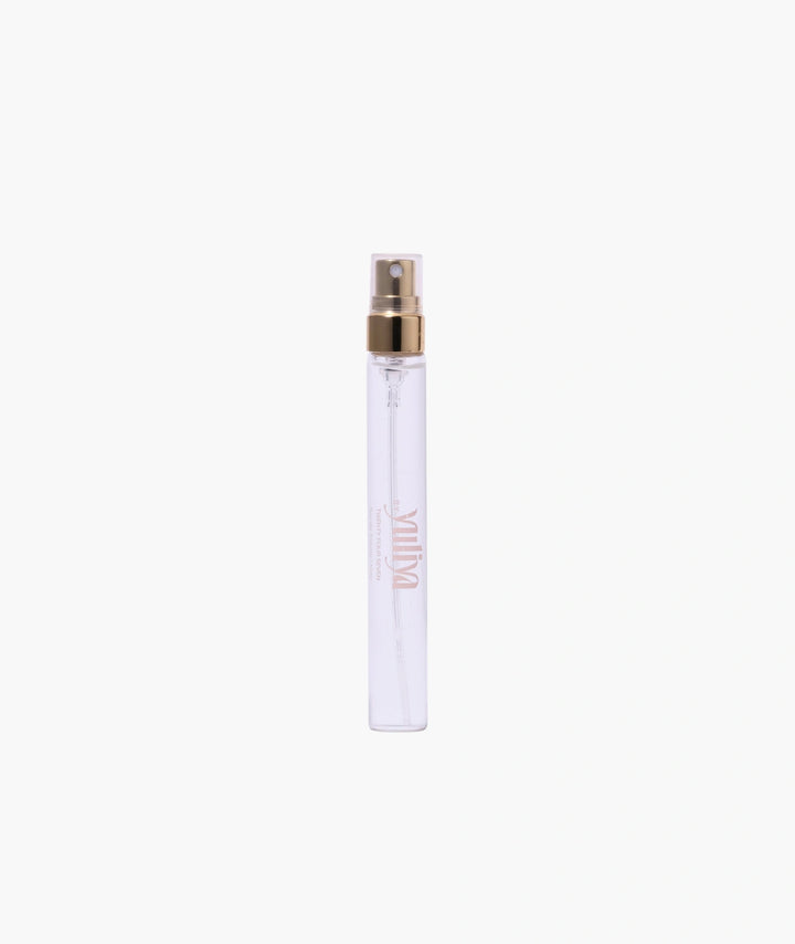 Clear spray bottle with gold cap on a white background