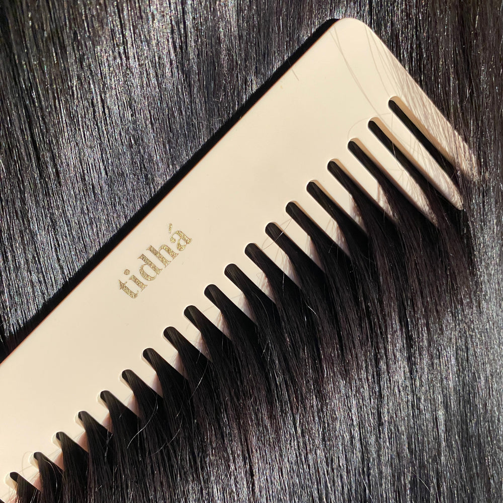 Sustainable tidhá branded detangling comb made of biodegradable material, showcased on a plain background. The comb’s beige color and eco-friendly design make it an attractive choice for environmentally conscious consumers looking for haircare tools