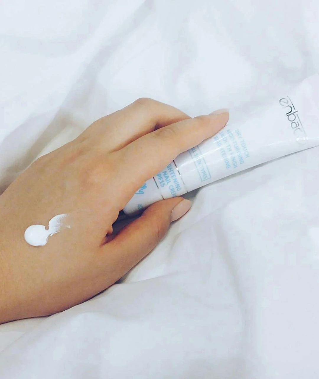 Enbacci Brightening Hand & Nail Cream SPF15 40ml with cream applied to skin, nourishing hand cream for hydration, nail care, UV protection and brighter-looking hands.
