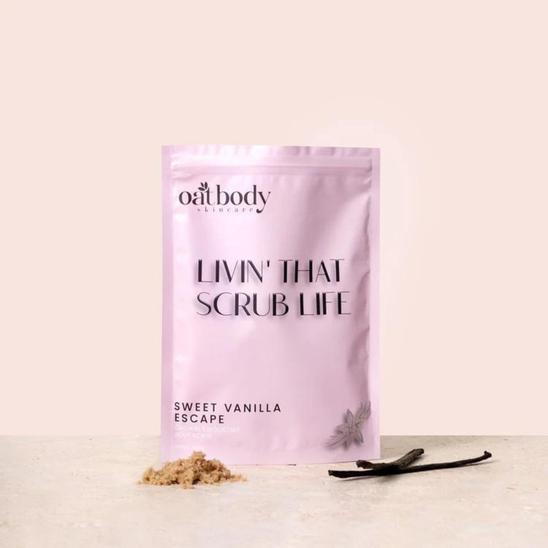 Sweet Vanilla Escape body scrub by Oatbody Skincare, a luxurious organic exfoliant, with a heap of natural scrub and vanilla pods on a soft pink background. The product is a gentle body scrub, this product helps with bumpy, rough, dry skin, strawberry skin, and keratosis pillaris.