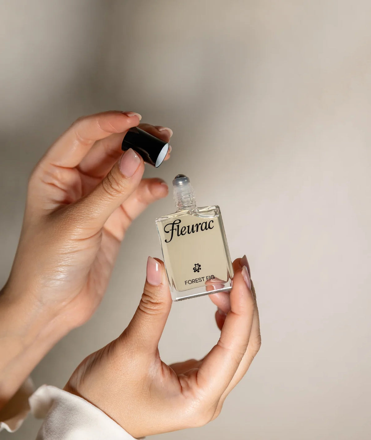 Fleurac Forest Fig Perfume — Hands opening clear glass bottle | Natural woody botanical fragrance