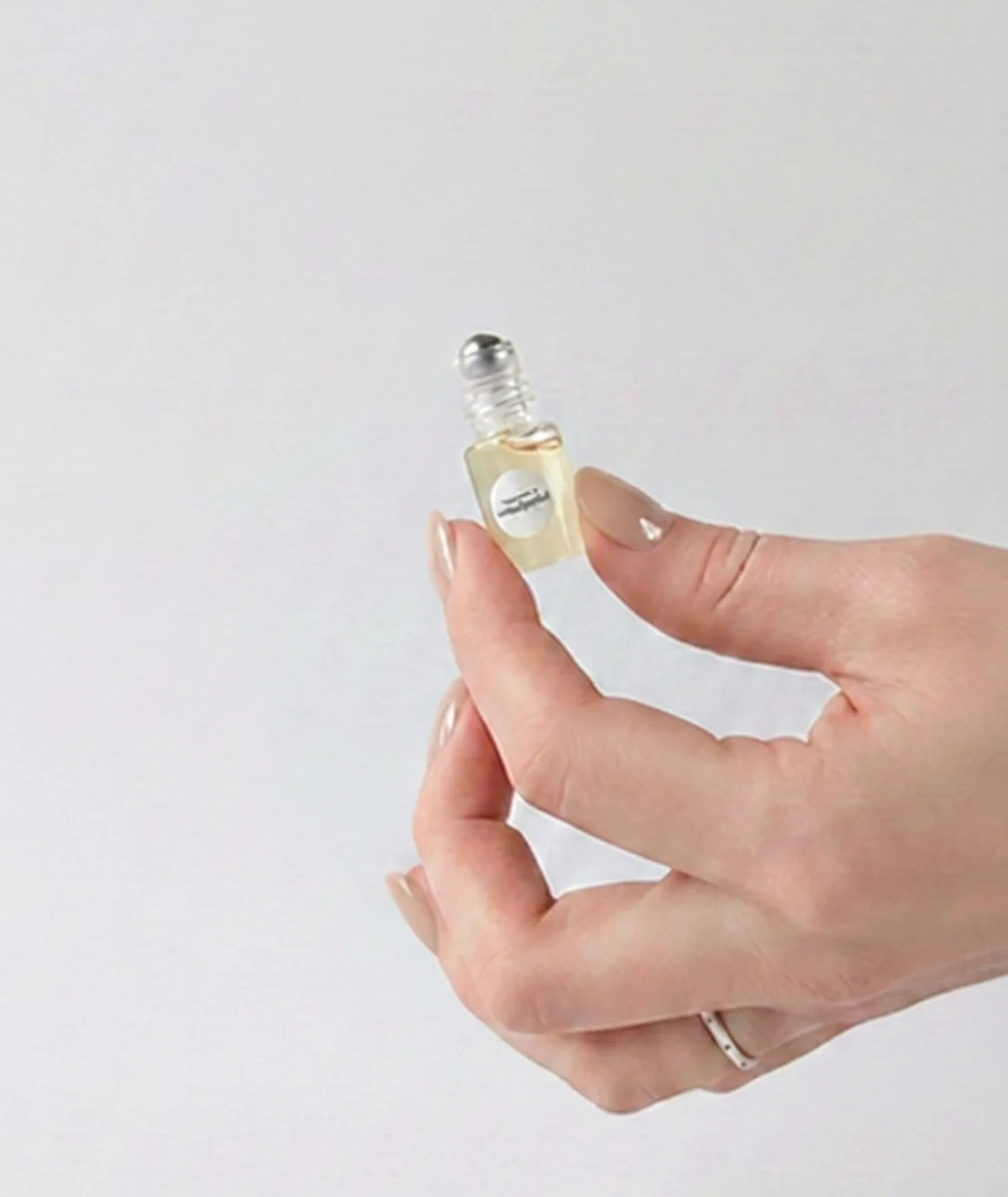 Fleurac Fragrance Discovery Set — Hand holding tiny 2ml mini perfume rollerball sample vial