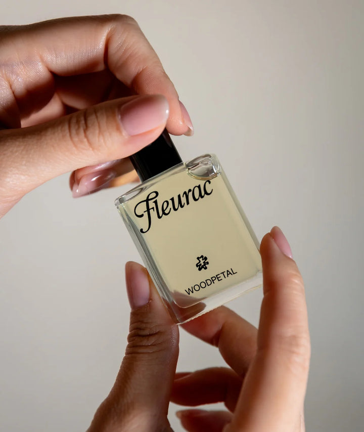 Fleurac Woodpetal Perfume — Close-up of hand holding spray bottle cap | Natural luxury fragrance