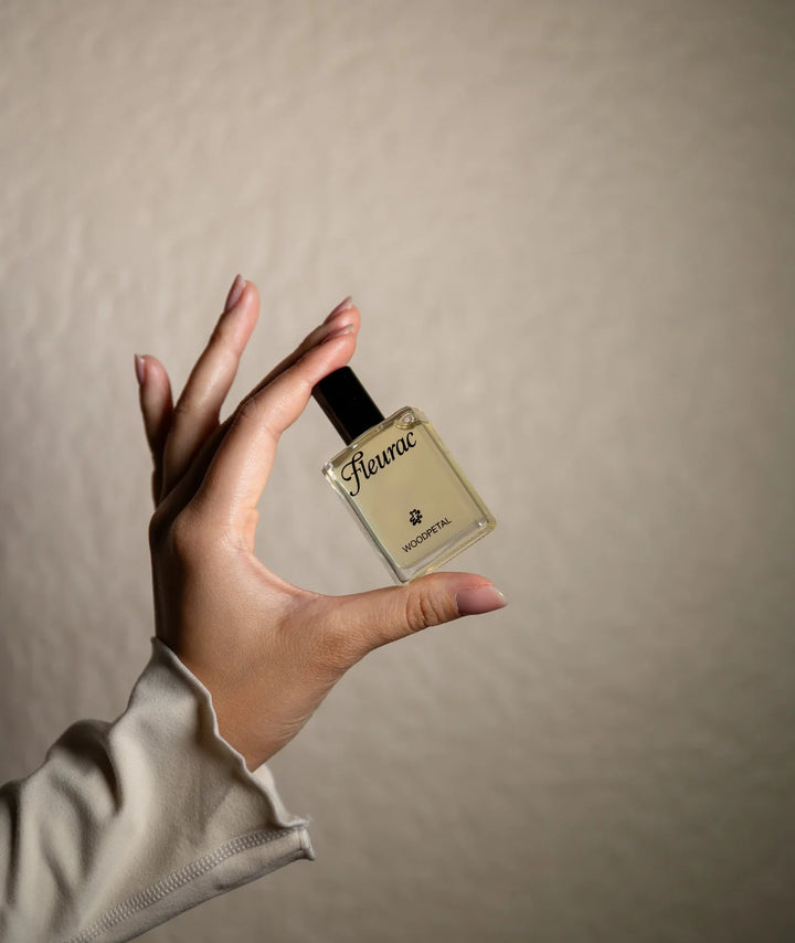 Woodpetal Perfume by Fleurac — Hand holding clear glass spray bottle | Warm woody floral eau de parfum