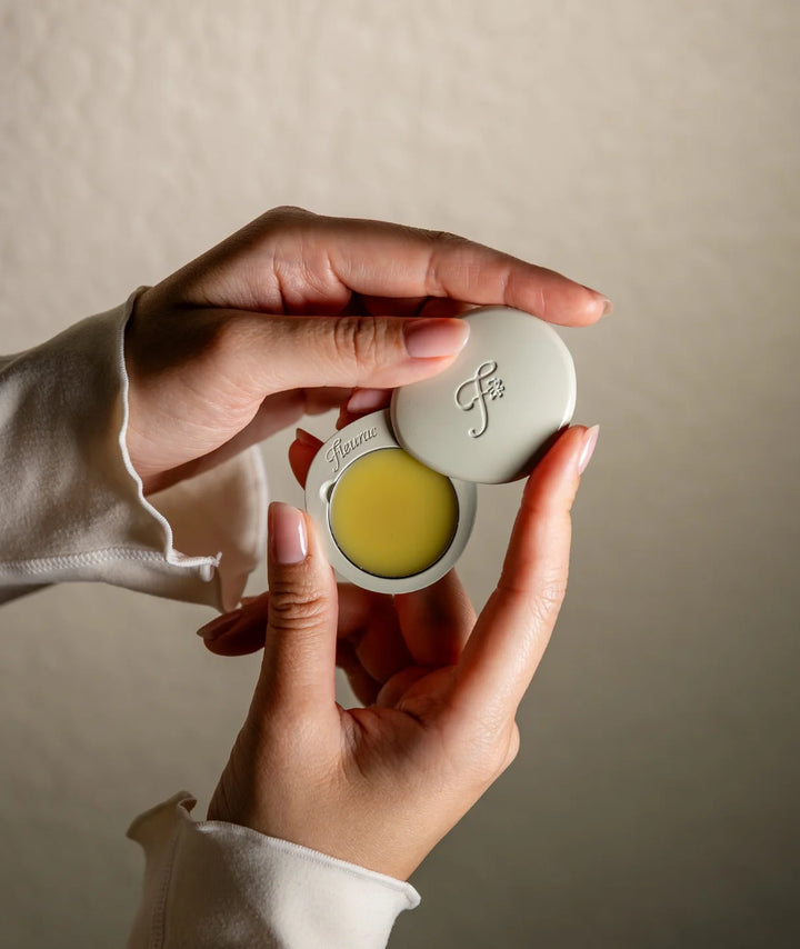 Fleurac Woodpetal Solid Perfume — Hands holding open pebble compact with solid fragrance balm