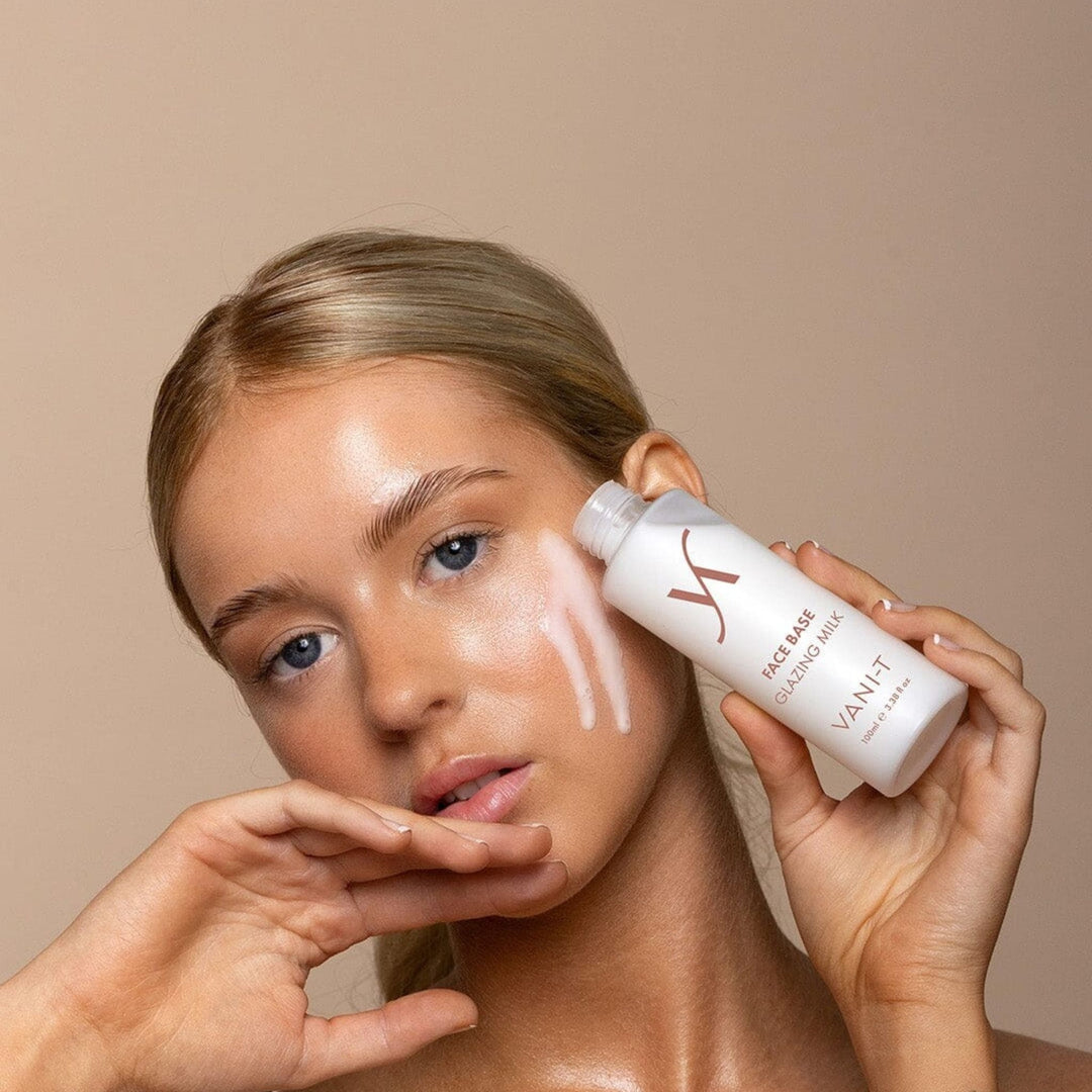 Woman applying glazing milk Australia to her face with a beige background.