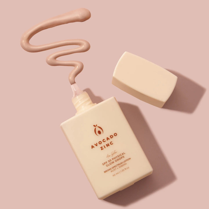 Avocado Zinc best glow drops for face product with a pump and applicator on a pink background