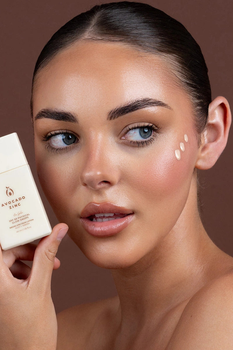 Woman holding best glow drops for face product with a brown background