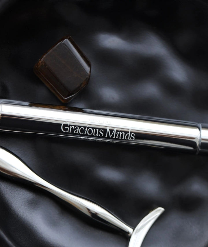 Gracious Minds Ambers Aura natural perfume oil roller with a brown crystal.