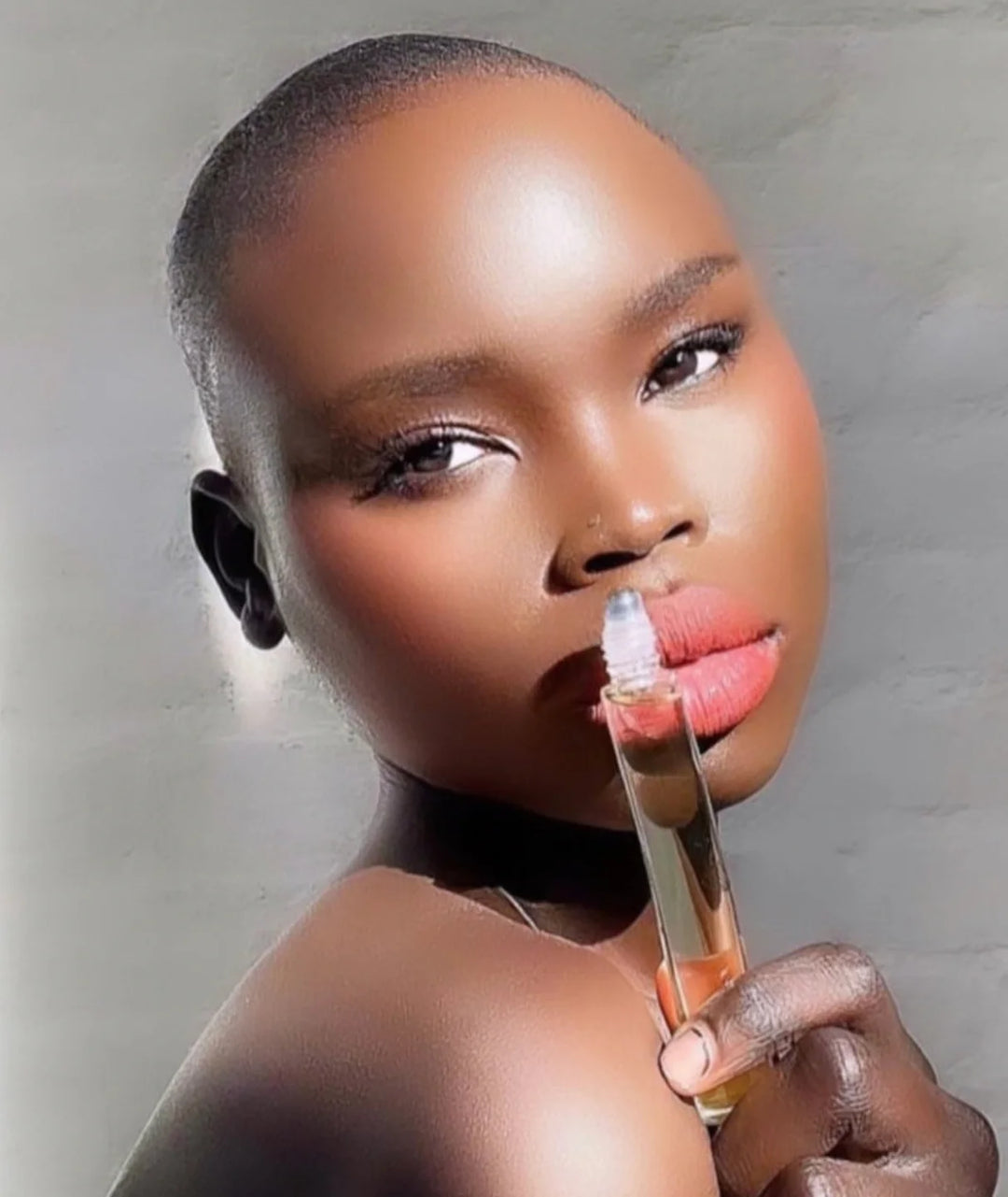 Model holding Serene Bodyhealth Amplify 100% pure essential oil perfume rollerball.