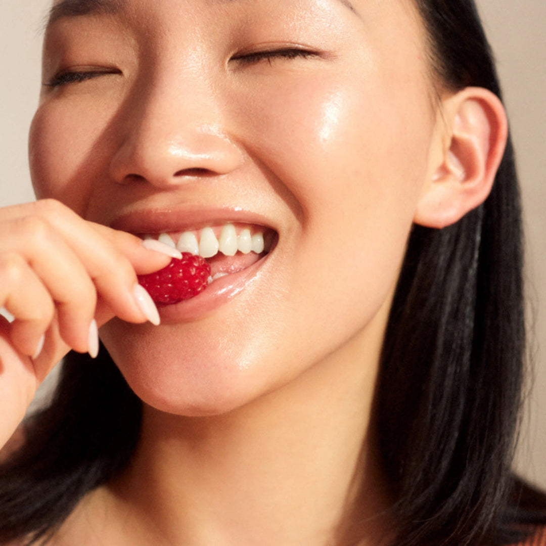 Innour marine collagen powder australia	model showing beautiful glowing skin while eating a raspberry. Best collagen supplements. 