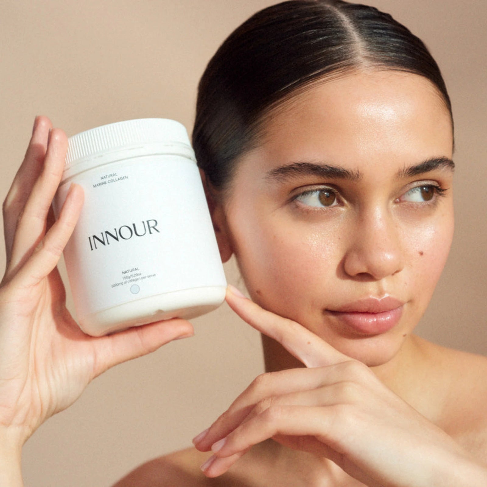 Woman with glowing skin holding the best collagen powder australia Innour