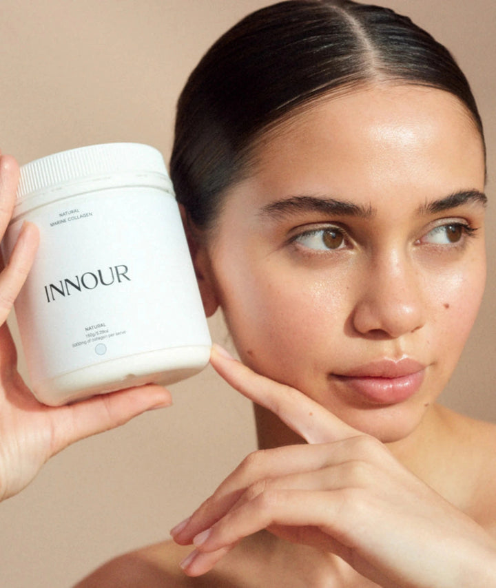 Model holding Innour Natural Marine Collagen 150g, a premium marine collagen powder supplement formulated to support healthy-looking skin, hair and nails.