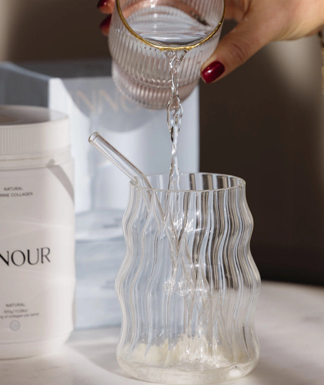Preparing Innour Natural Marine Collagen 150g by adding water to collagen powder, creating a daily beauty supplement drink for skin hydration and wellness support.