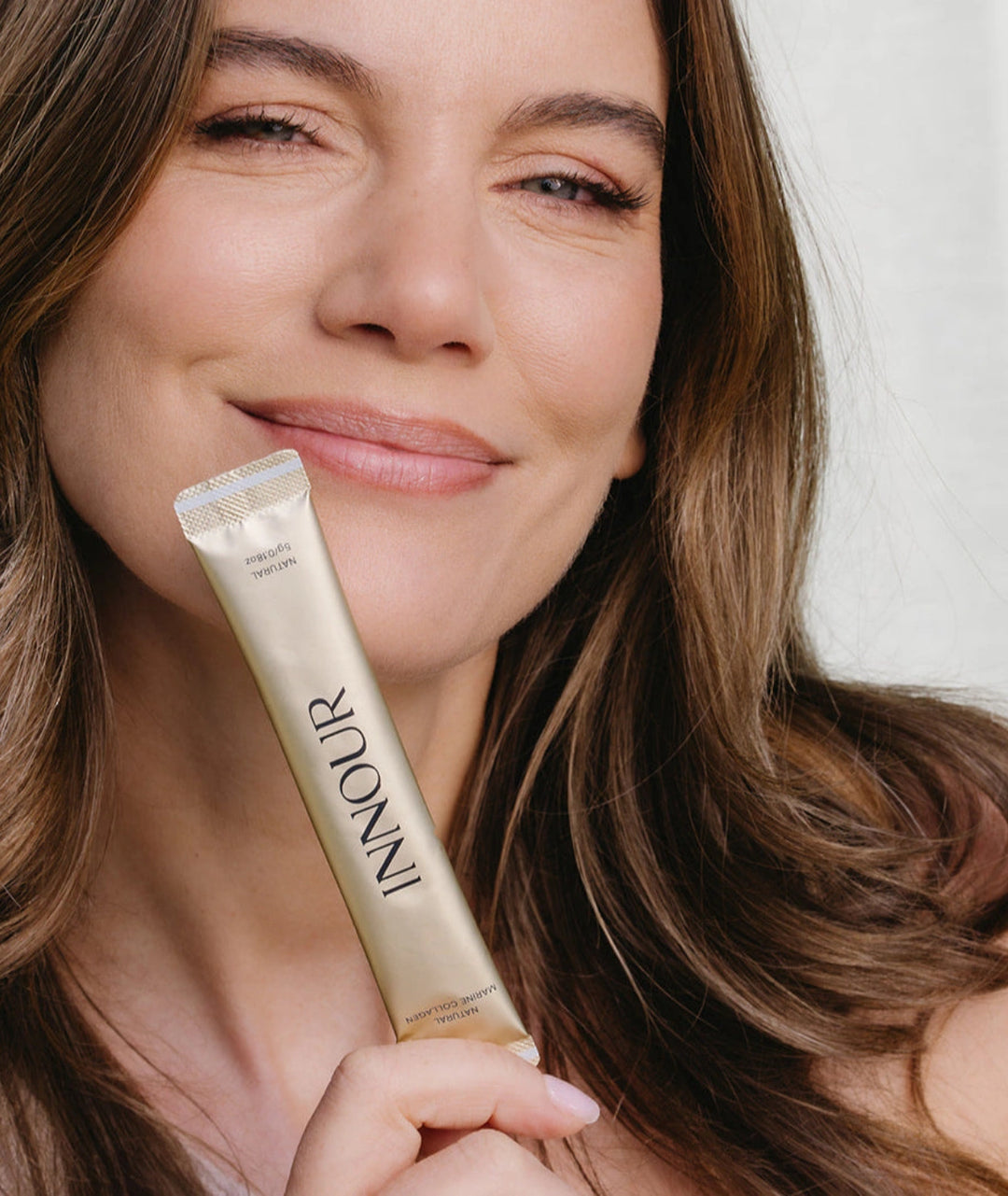 Model holding Innour Natural Marine Collagen sachet, showcasing a convenient daily marine collagen supplement for healthy skin, hair and nails.