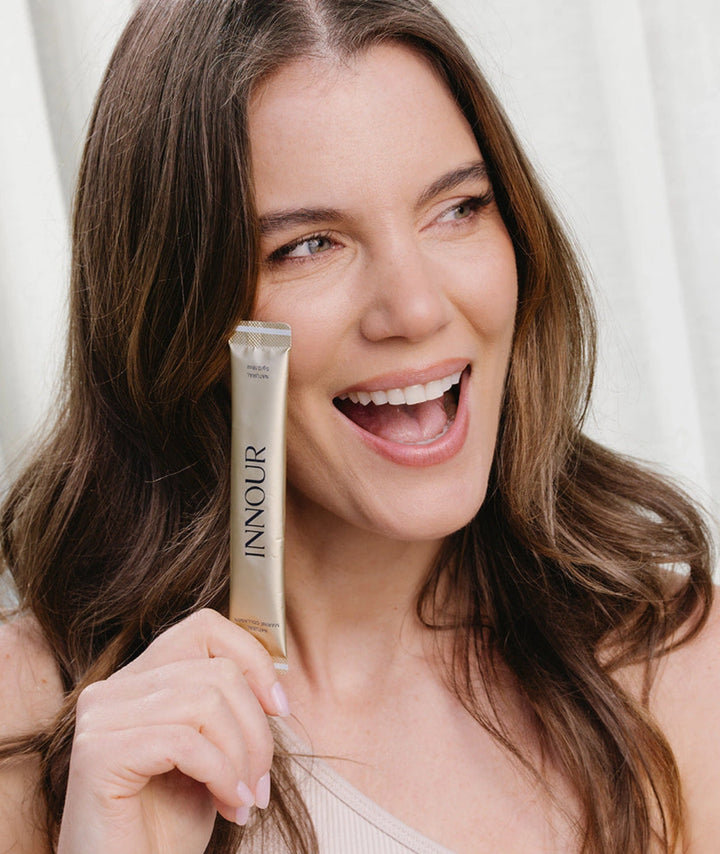 Model holding Innour Natural Marine Collagen sachet, showcasing a convenient daily marine collagen supplement for healthy skin, hair and nails.