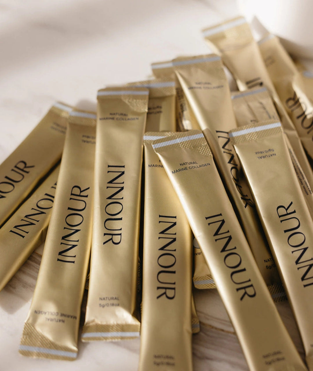 Individual Innour Natural Marine Collagen sachets arranged together, travel friendly marine collagen supplementation for skin, hair and nail support.