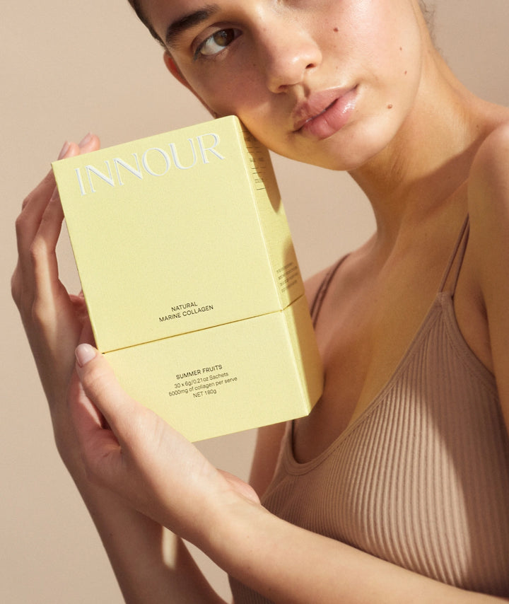 Woman holding Innour Natural Marine Collagen Summer Fruits 30 Sachets, showcasing a premium Australian marine collagen supplement designed to support skin hydration, healthy-looking skin, hair and nail wellness.