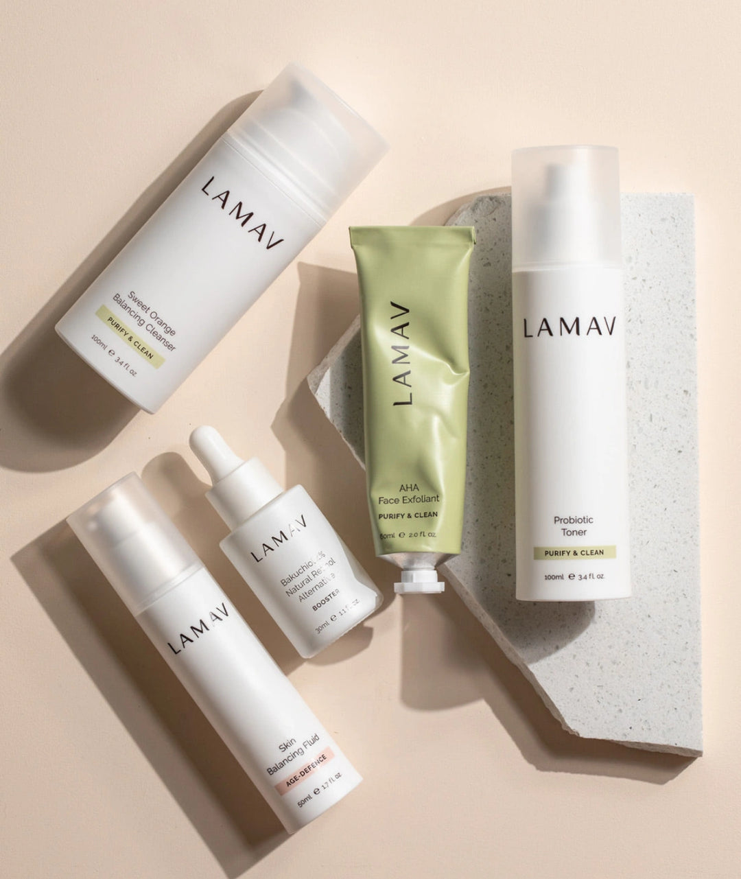 LAMAV Acne Essential Kit displayed on natural stone featuring probiotic toner, bakuchiol serum, balancing cleanser and AHA exfoliant for oily and blemish-prone skin.