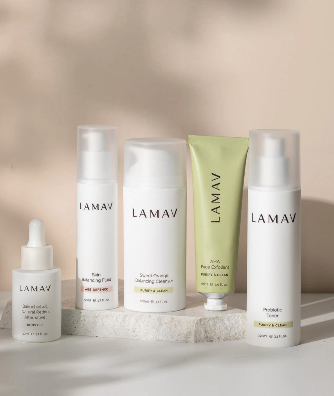 Flat lay of LAMAV Acne Essential Kit including Bakuchiol 4% Booster, Probiotic Toner, Skin Balancing Fluid, Sweet Orange Cleanser and AHA Face Exfoliant.