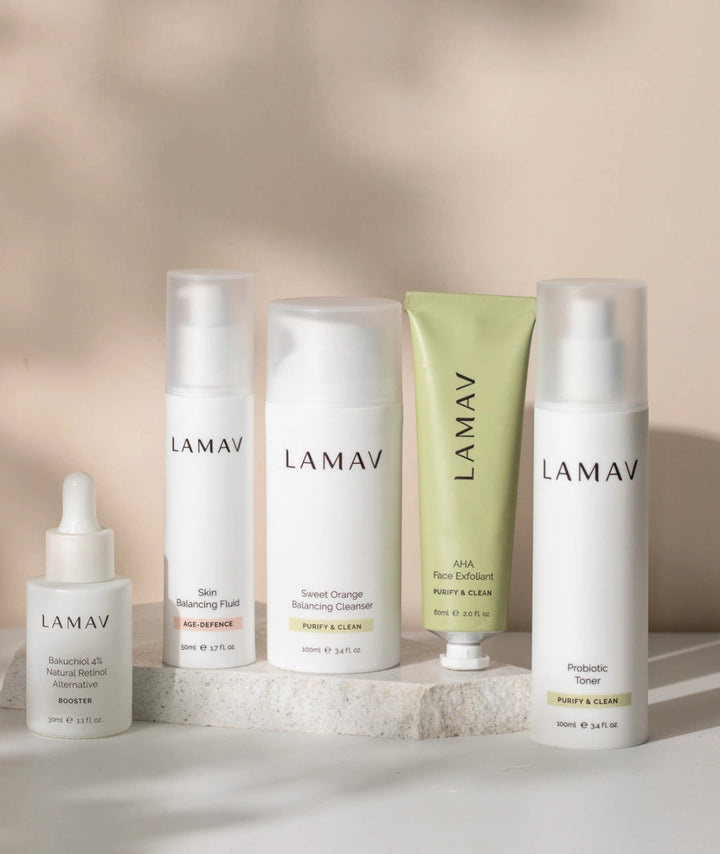 Flat lay of LAMAV Acne Essential Kit including Bakuchiol 4% Booster, Probiotic Toner, Skin Balancing Fluid, Sweet Orange Cleanser and AHA Face Exfoliant.