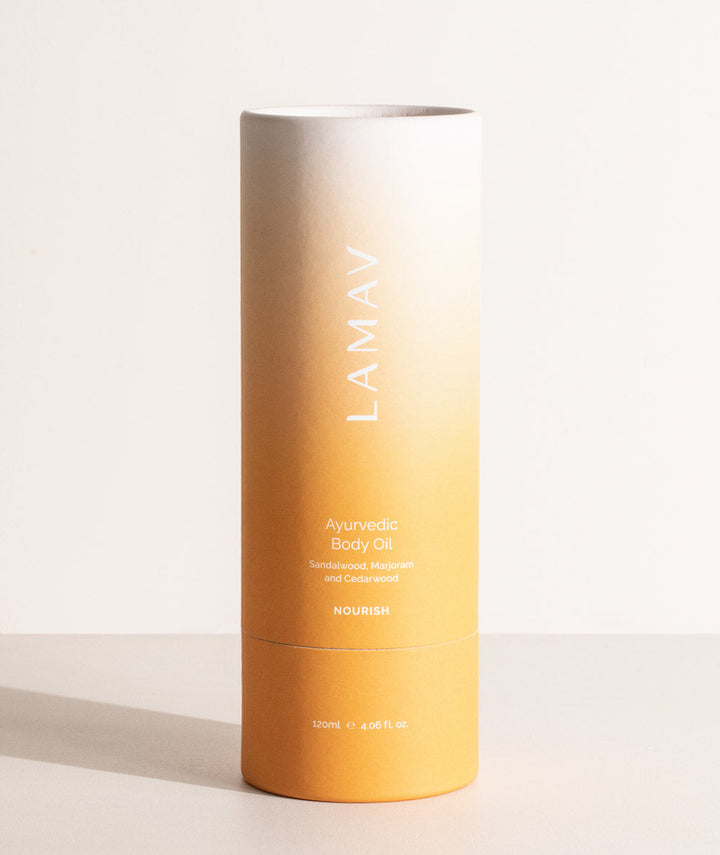 LAMAV Ayurvedic Body Oil Nourish in its eco-friendly orange cylindrical tube packaging.
