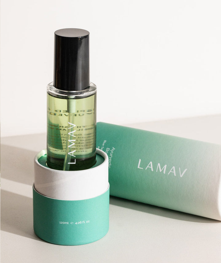 LAMAV Ayurvedic Body Oil Uplift. Green bottle displayed in matching cylindrical packaging.