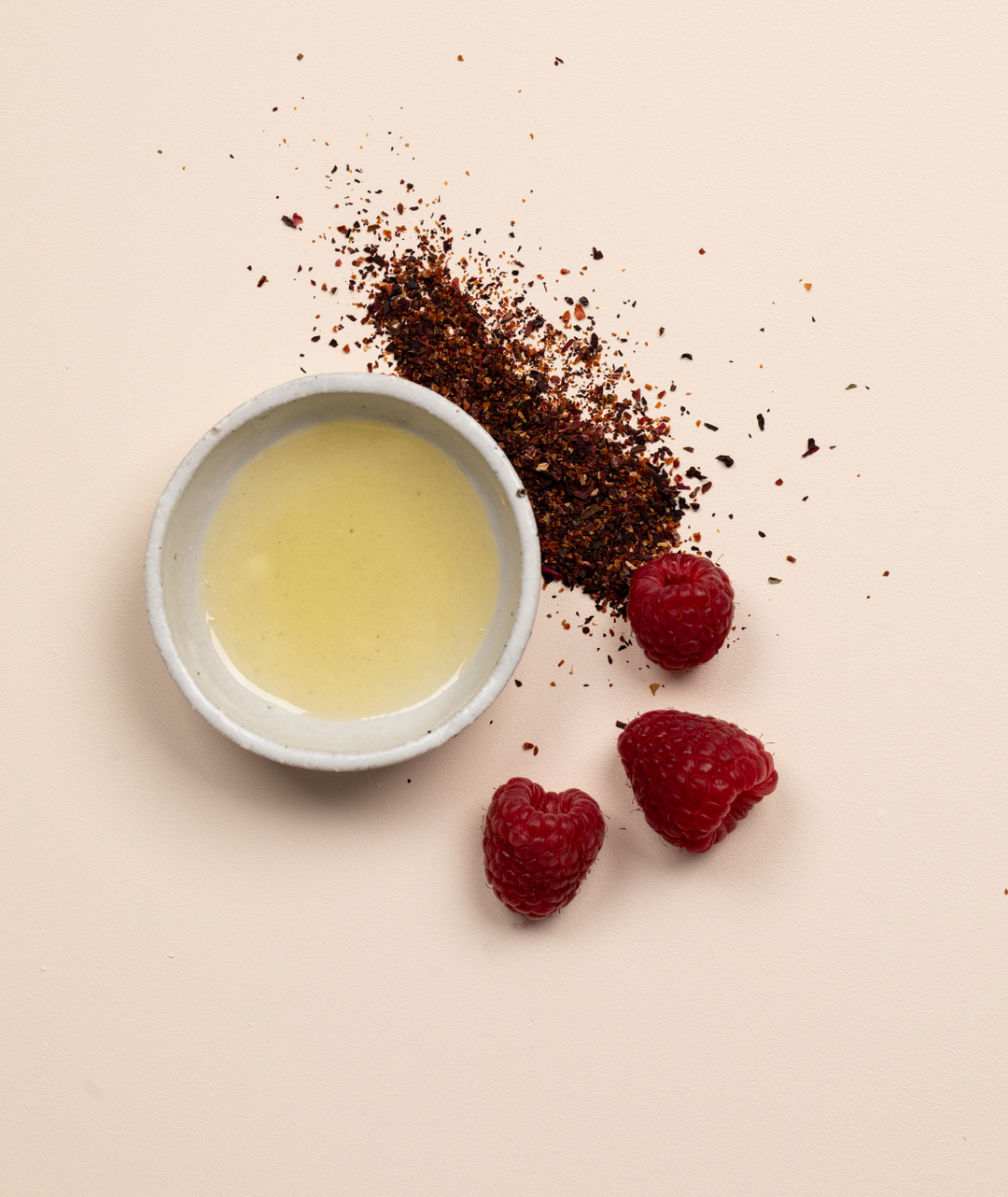 LAMAV double cleansing duo botanical ingredients featuring cleansing oil, herbs, and raspberries on a flat lay.