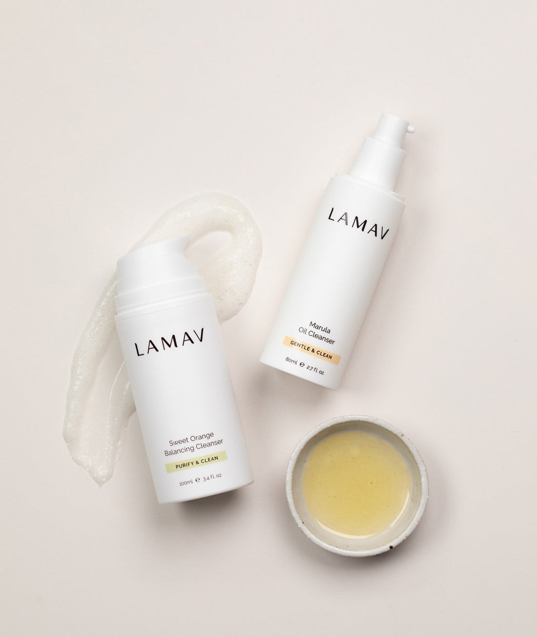Open pump bottles of LAMAV Double Cleansing Duo for oily skin resting on a clean surface with shadows.