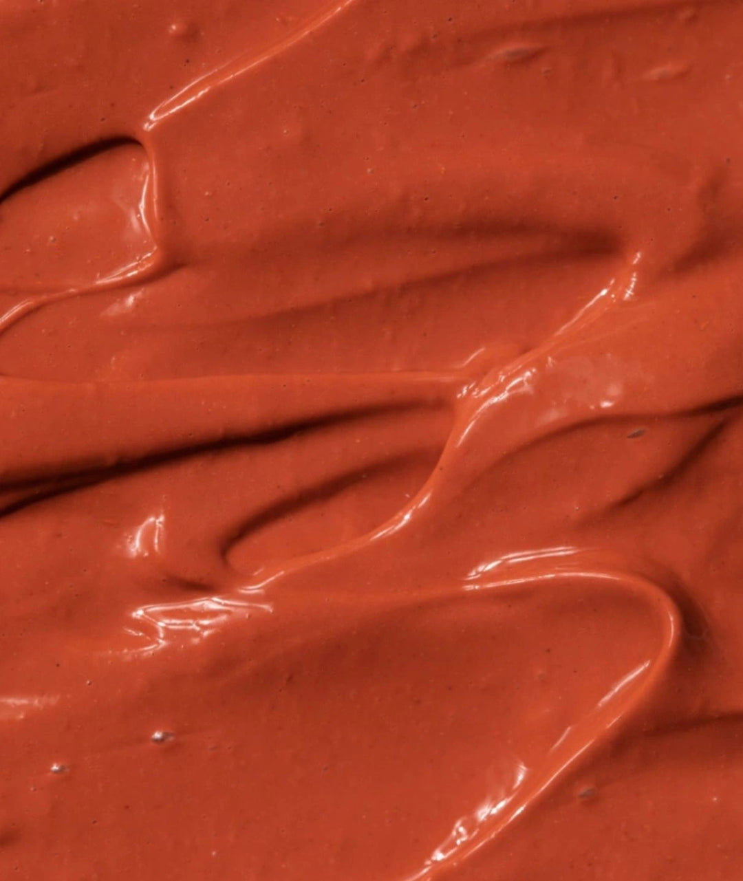Close-up texture of LAMAV Firming Treatment Mask. Rich terracotta clay mask for anti-aging skincare.