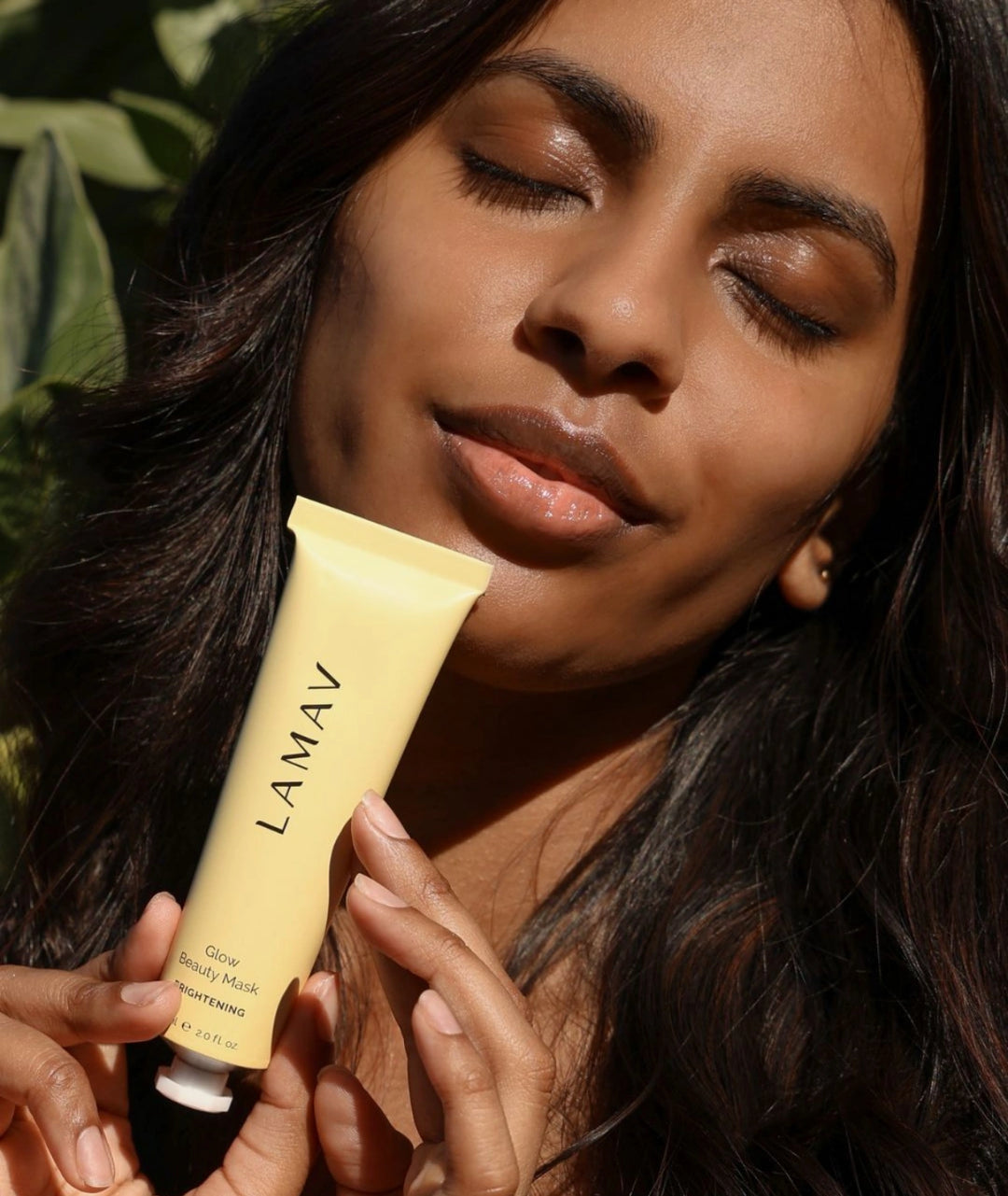 Woman applying LAMAV Glow Beauty Mask brightening treatment designed to exfoliate, revitalise dull skin and reveal a more radiant, even-looking complexion.