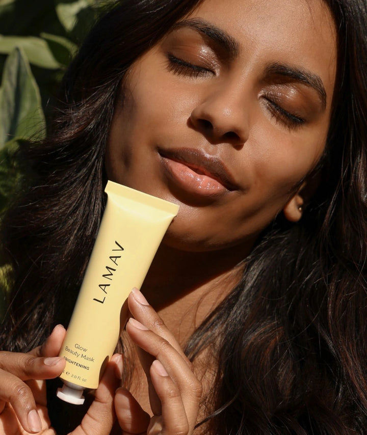 Woman applying LAMAV Glow Beauty Mask brightening treatment designed to exfoliate, revitalise dull skin and reveal a more radiant, even-looking complexion.