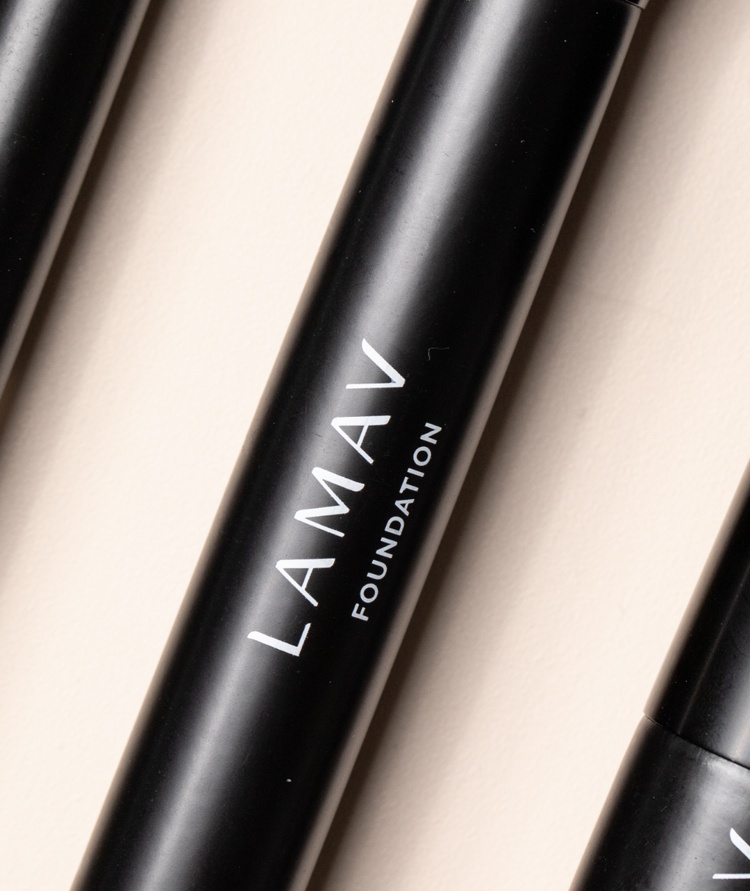 Close-up of the LAMAV Vegan Foundation Brush handle. Premium black cruelty-free makeup tool detailing.